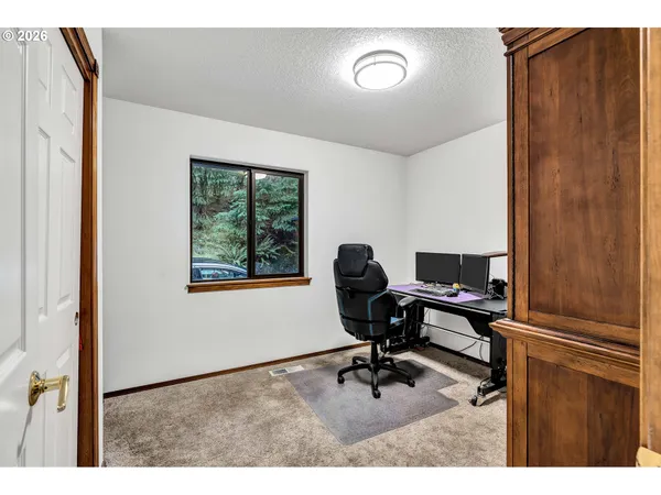 a view of a workspace with furniture and a window