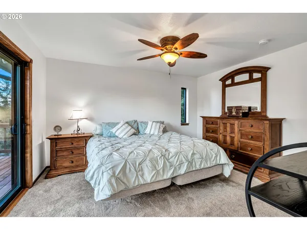 a bedroom with a bed a chandelier and a dresser