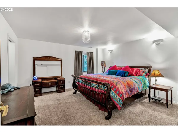 a spacious bedroom with a bed and a lamp