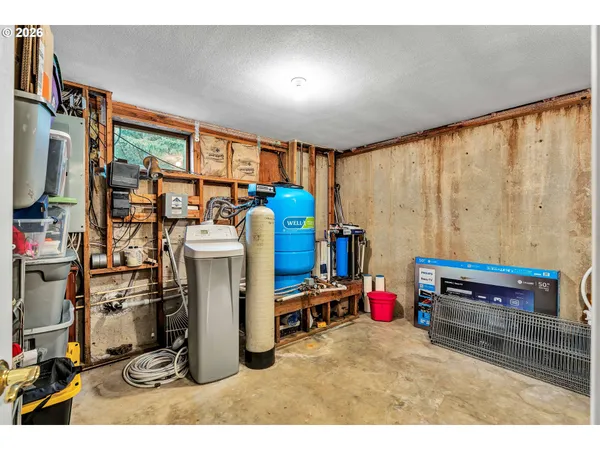 a storage room with washer and a view of living room