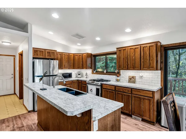 a kitchen with stainless steel appliances granite countertop a sink stove and refrigerator