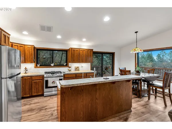 a kitchen with stainless steel appliances a sink stove and wooden floor
