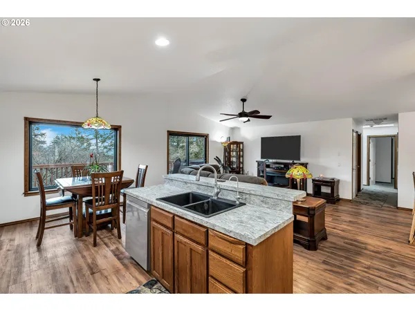 a kitchen with a stove a kitchen island a dining table and chairs with wooden floor