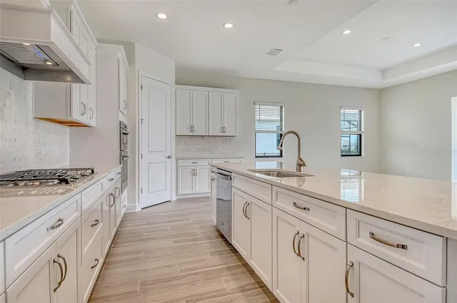 a kitchen with sink stove and cabinets