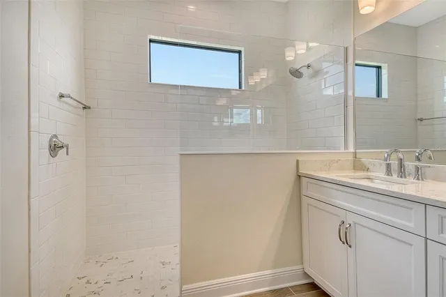 a bathroom with a sink a mirror and a shower