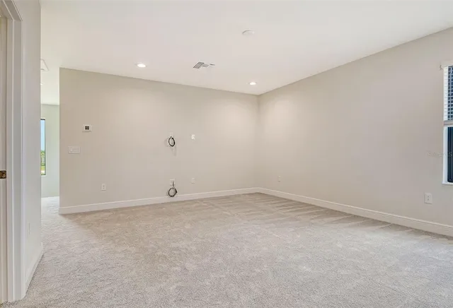 a view of an empty room with closet and a window