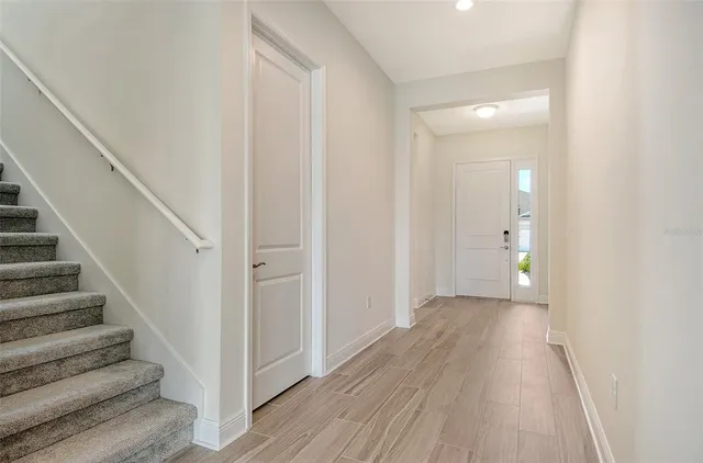 a view of a hallway with wooden floor and entryway