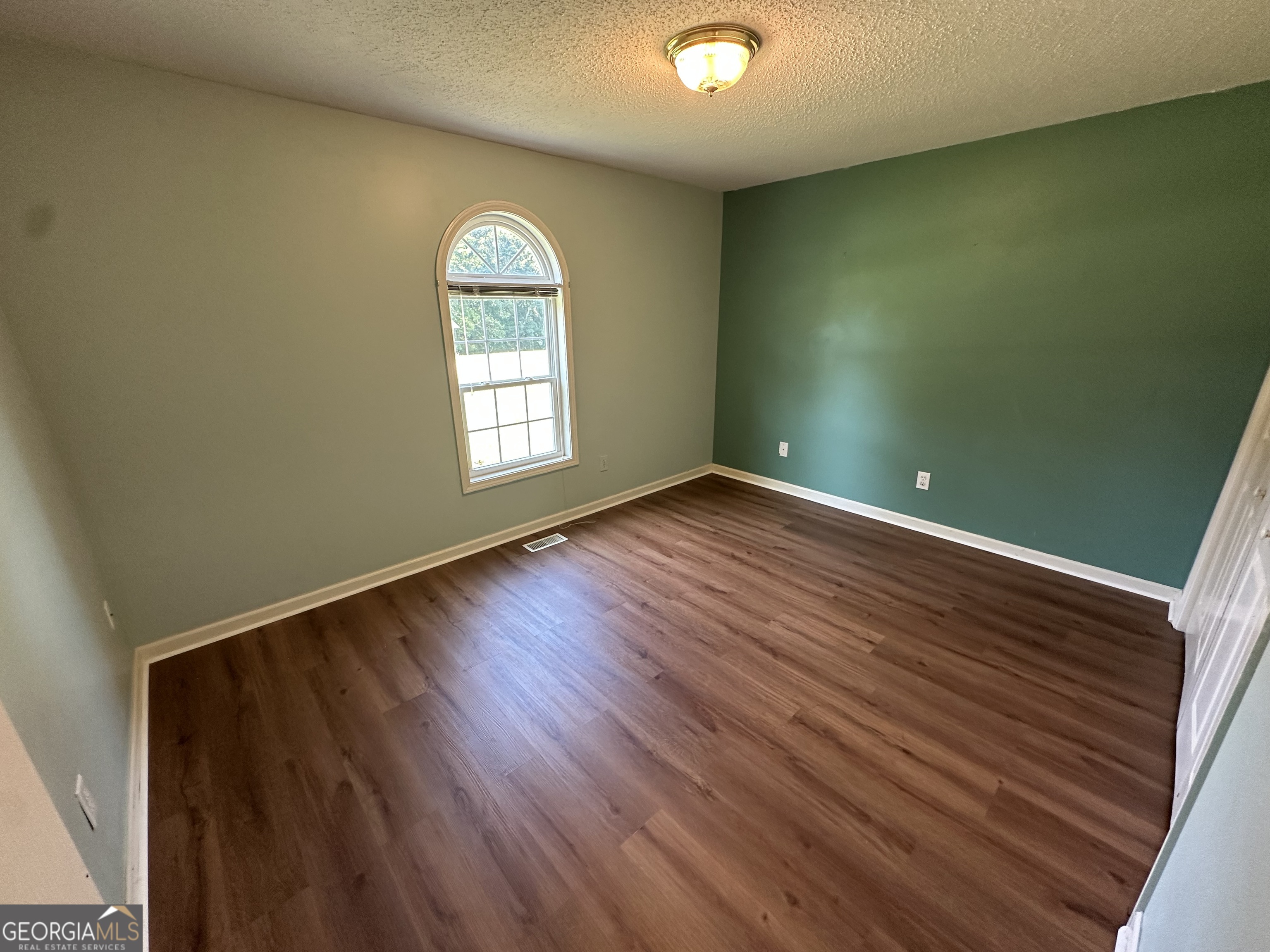 384 Sam Brown Boulevard Commerce, GA 30529 - Photo 7 of 25 an empty room with wooden floor and windows
