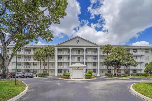 a front view of a building with a garden and plants