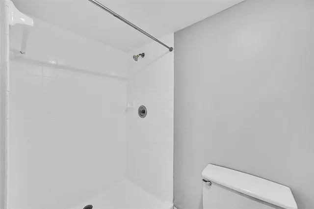 a bathroom with a toilet and a shower