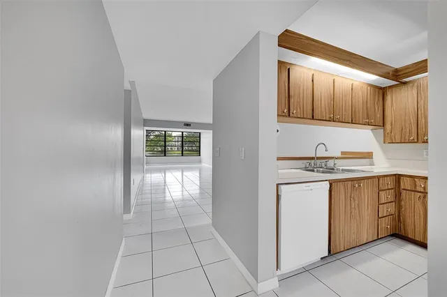 a kitchen with granite countertop a sink window and cabinets