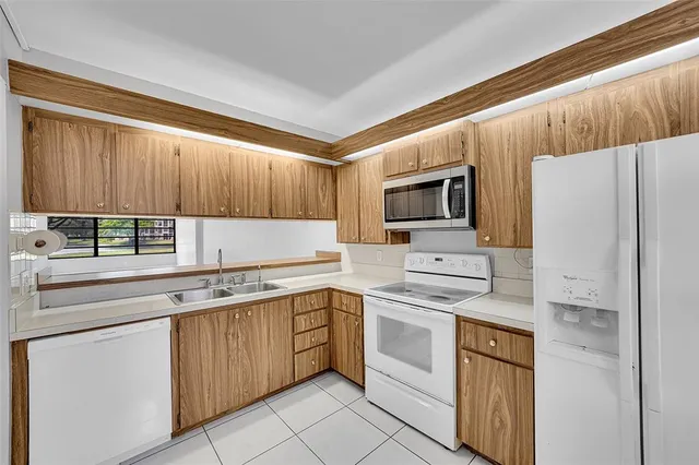 a kitchen with a sink appliances and cabinets
