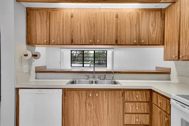 a kitchen with stainless steel appliances granite countertop a sink a cabinets and a window
