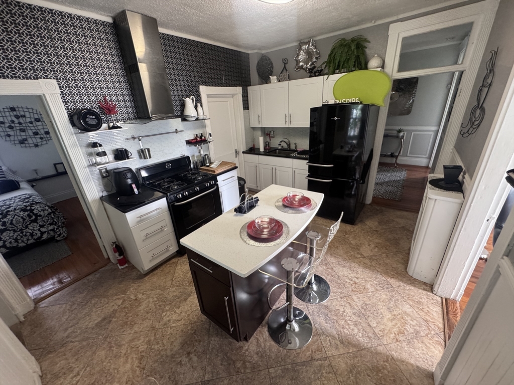 a kitchen with a refrigerator a stove a sink and a dining table