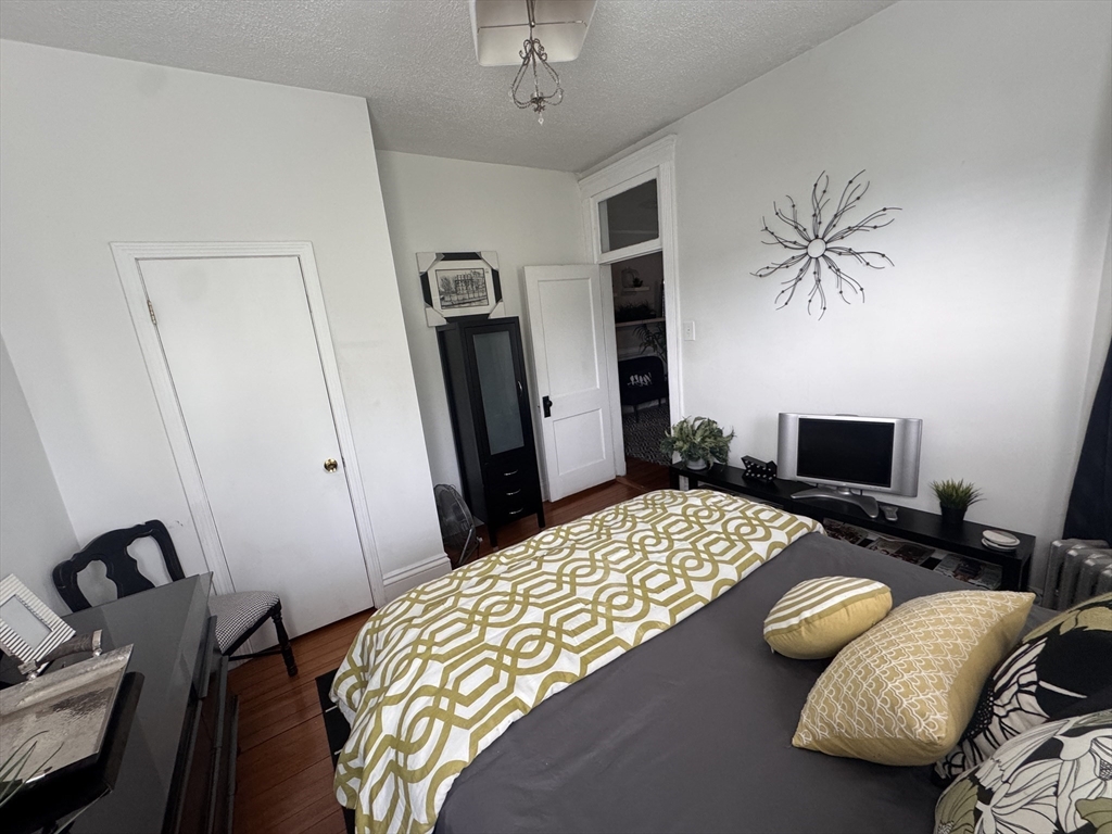 40 Arbutus Street, Unit 3 Boston, MA 02124 - Photo 4 of 8 a bedroom with a bed and a flat screen tv