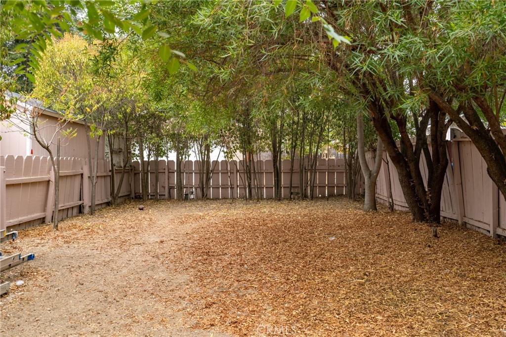 1803 Pine Street Paso Robles, CA 93446 - Photo 16 of 18 a backyard of a house with large trees and a wooden fence