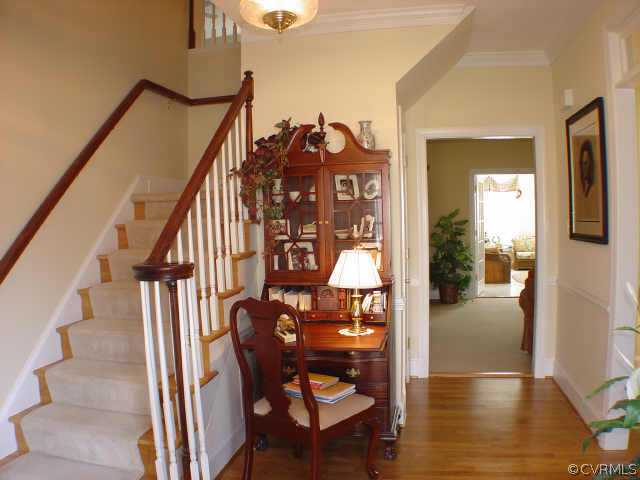 14401 Newgate Road Midlothian, VA 23113 - Photo 2 of 10 a view of a hallway with wooden floor and staircase