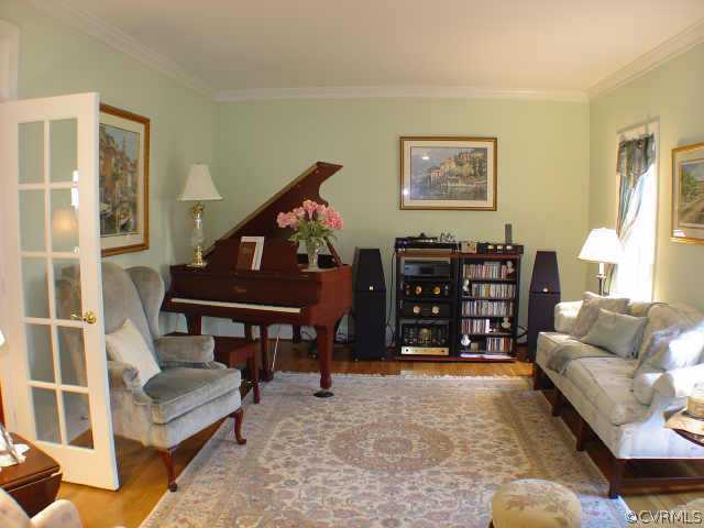 14401 Newgate Road Midlothian, VA 23113 - Photo 3 of 10 a living room with furniture a rug and a bookshelf
