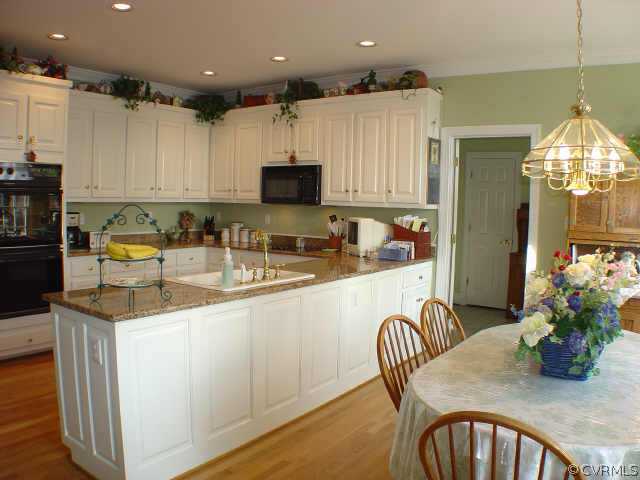 14401 Newgate Road Midlothian, VA 23113 - Photo 6 of 10 a kitchen with stainless steel appliances granite countertop a sink dishwasher a microwave oven with a dining table and chairs