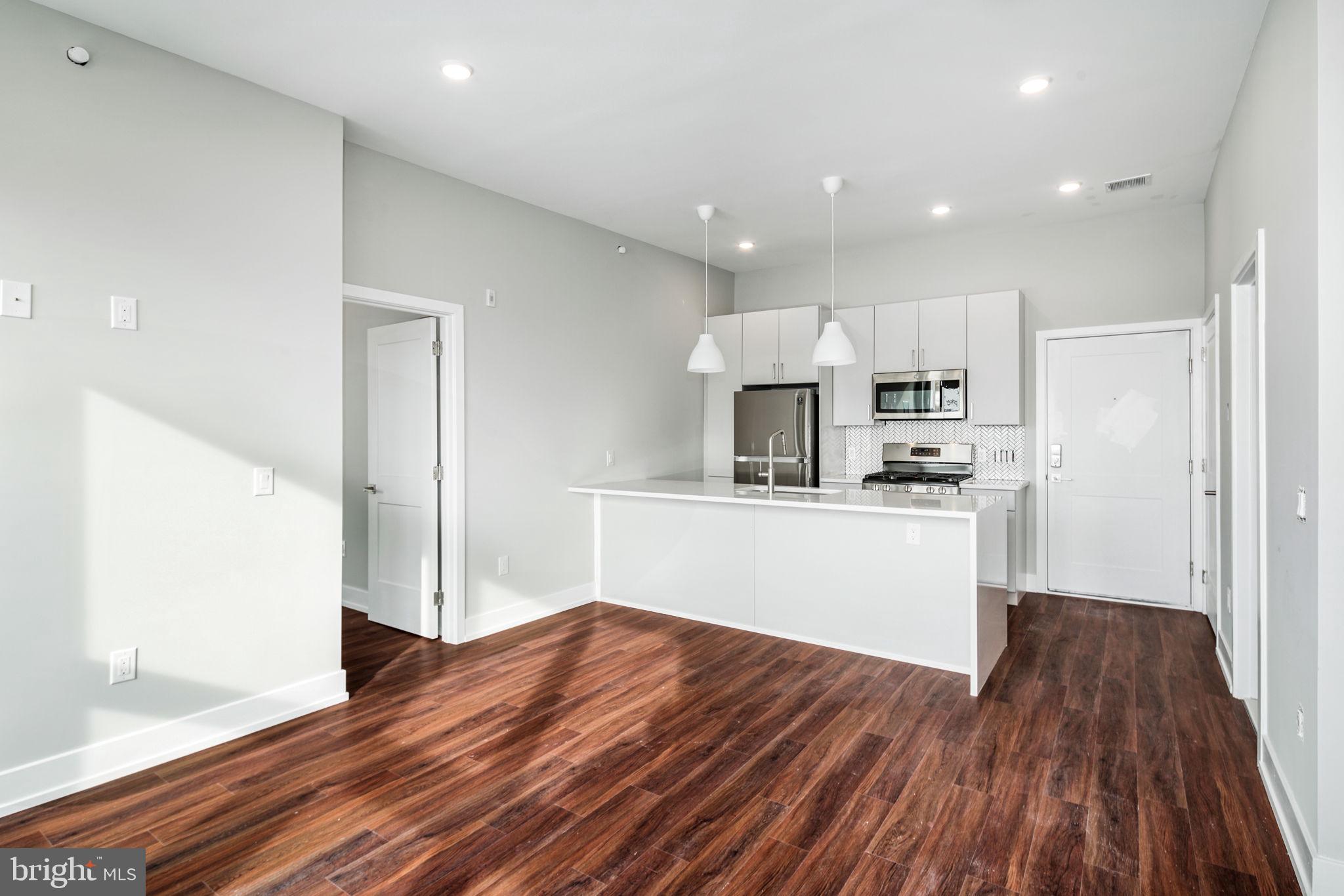 1527-29 Ridge Avenue, Unit 3A Philadelphia, PA 19130 - Photo 7 of 33 a kitchen with wooden floors and white cabinets