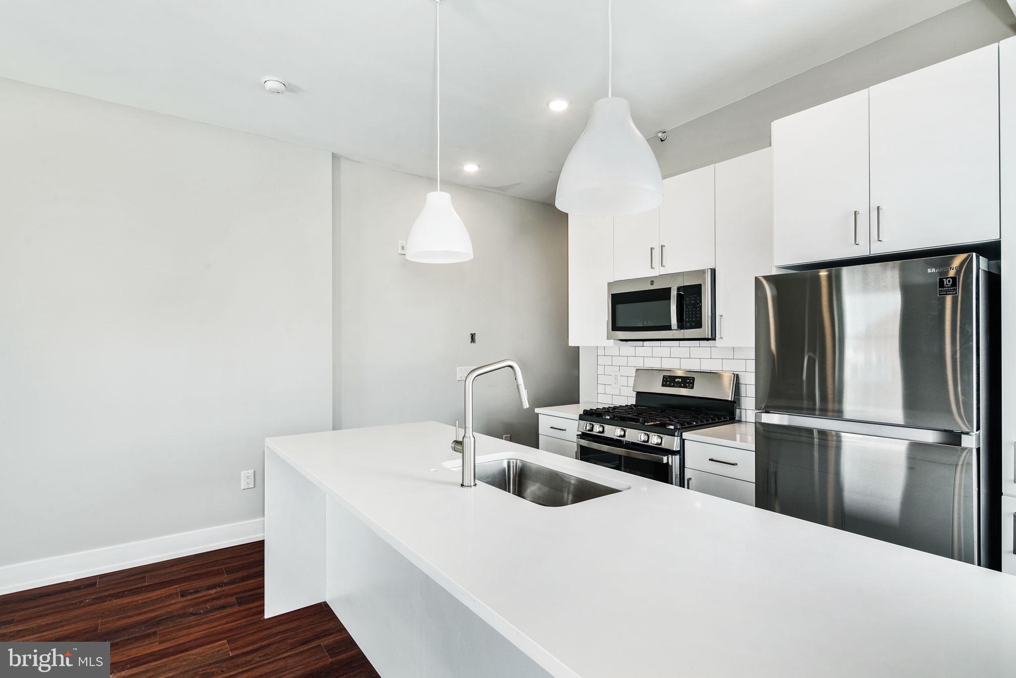 1527-29 Ridge Avenue, Unit 3A Philadelphia, PA 19130 - Photo 9 of 33 a kitchen with stainless steel appliances a refrigerator stove microwave and sink