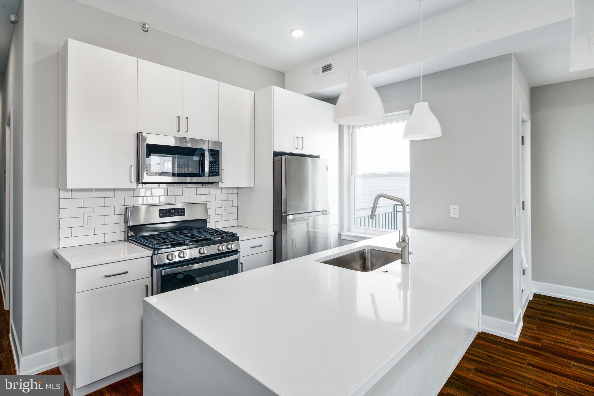 1527-29 Ridge Avenue, Unit 3A Philadelphia, PA 19130 - Photo 10 of 33 a kitchen with kitchen island a white counter top space stainless steel appliances and cabinets