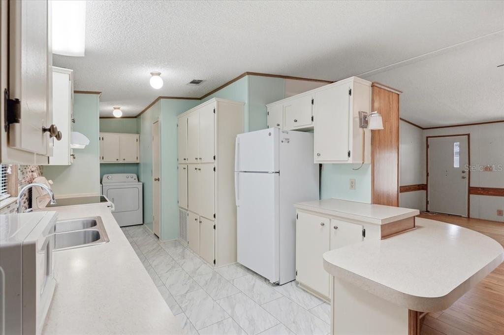 1798 Fox Hill Drive Lakeland, FL 33810 - Photo 13 of 41 a large white kitchen with a sink and refrigerator