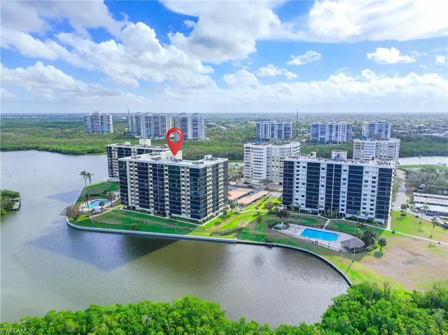 a view of a lake with a multi story building and a big yard