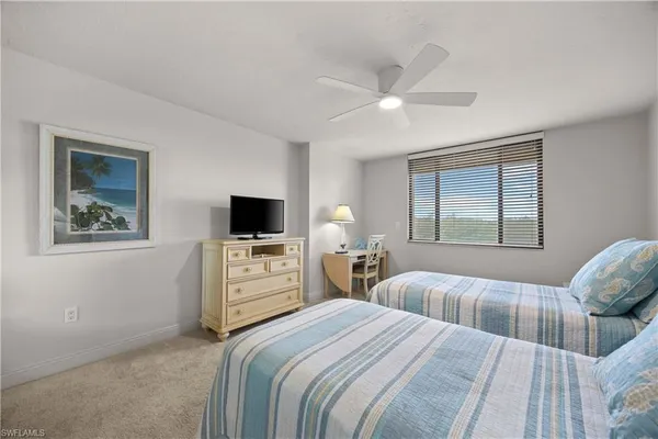 a bedroom with two beds and a window