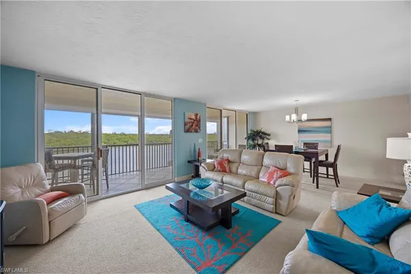 a living room with furniture and a large window with balcony view