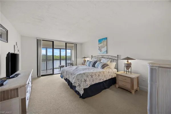 a bedroom with a bed flat screen tv and a window