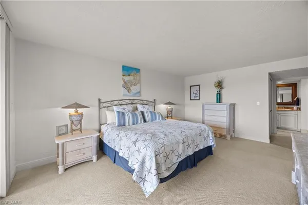 a spacious bedroom with a bed and a lamp