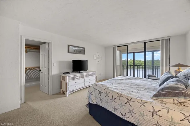 a bedroom with a large bed and a flat tv screen