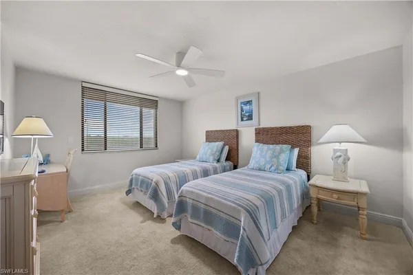 a bedroom with two beds and a lamp