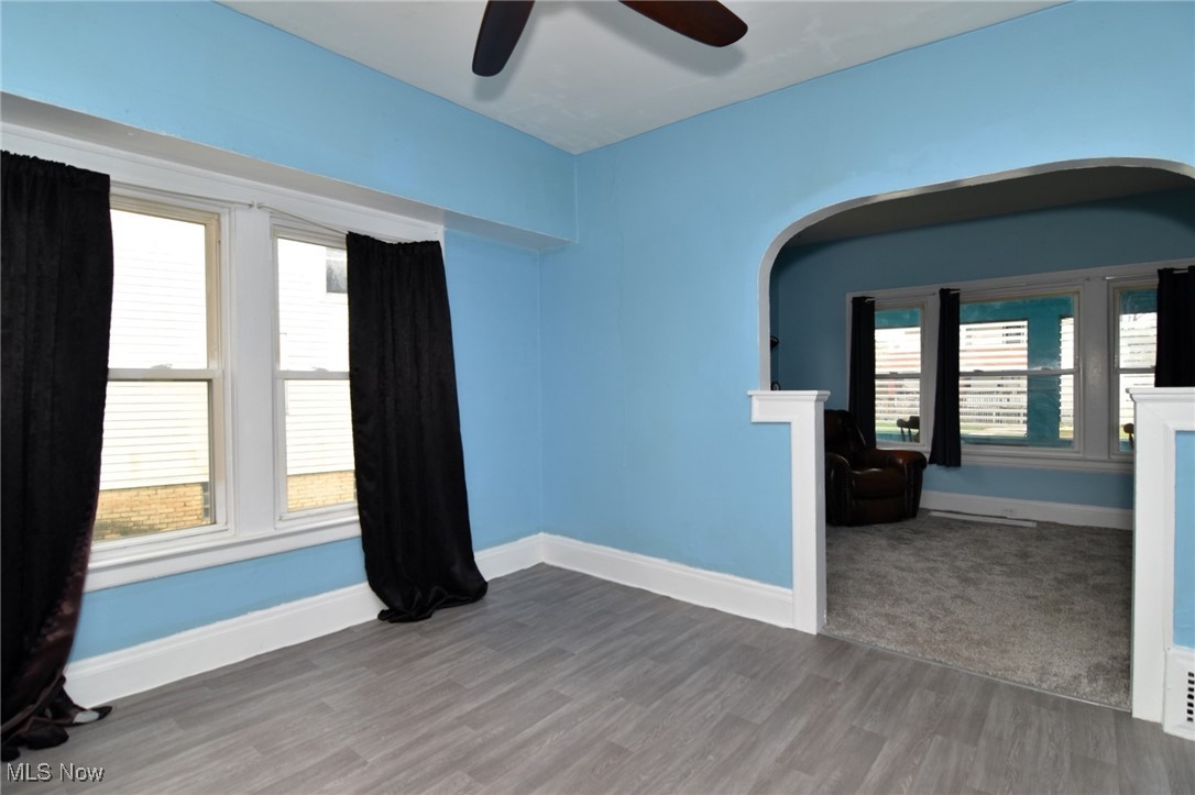 4213 Valley Road Cleveland, OH 44109 - Photo 10 of 47 Spare room with ceiling fan, wood finished floors, arched walkways, and baseboards