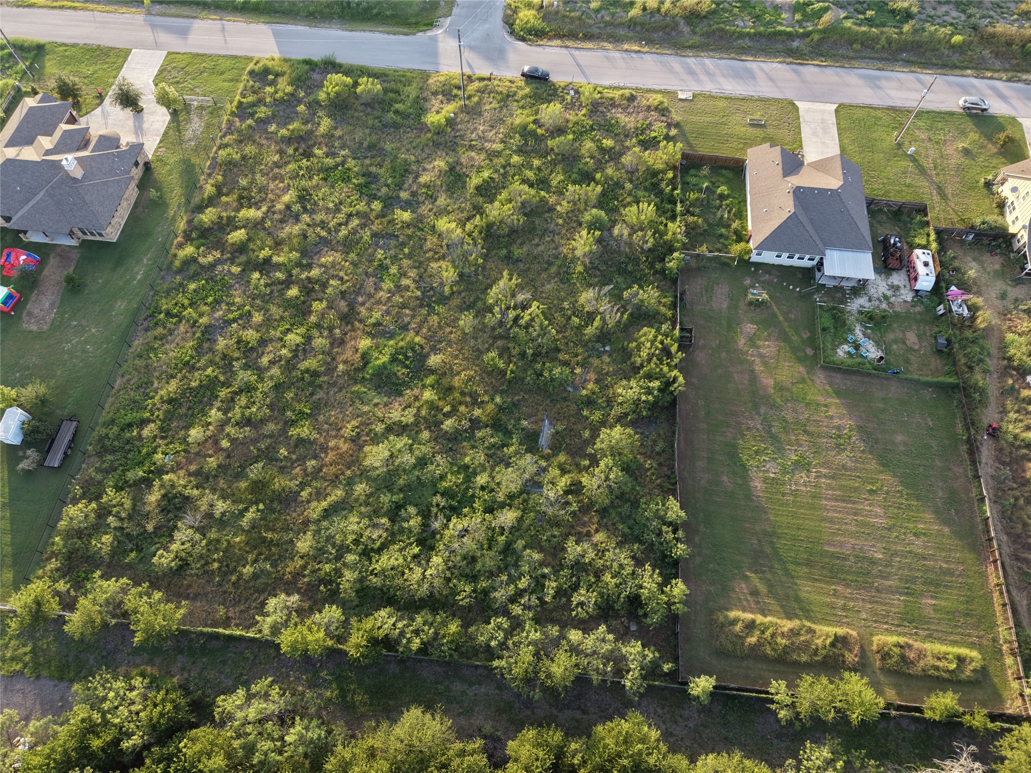 232 East Ridge Lane Kyle, TX 78640 - Photo 18 of 36 An aerial perspective reveals a sizable, verdant lot ready for development, bordered by existing residences.