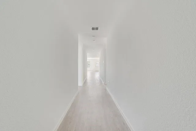 a view of a hallway with wooden floor