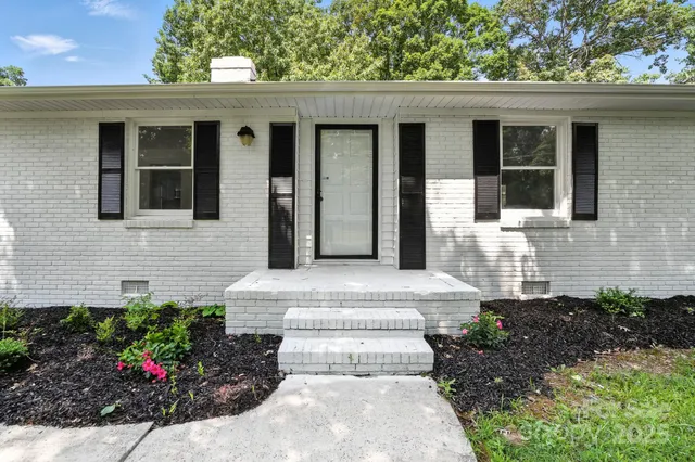 a front view of a house with a garden