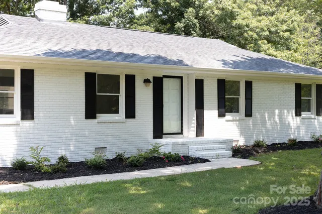 a front view of a house with a garden and plants
