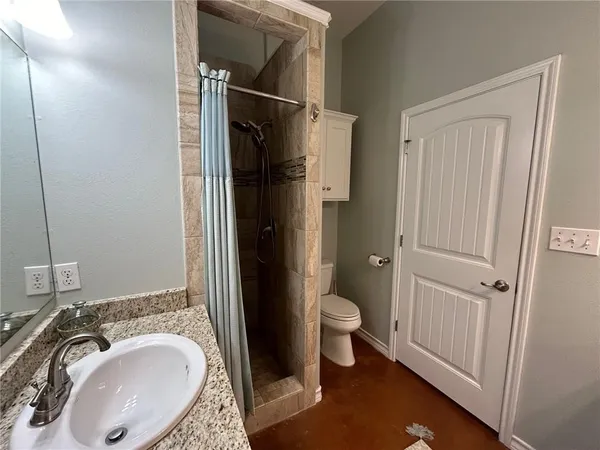 a bathroom with a granite countertop sink toilet and shower