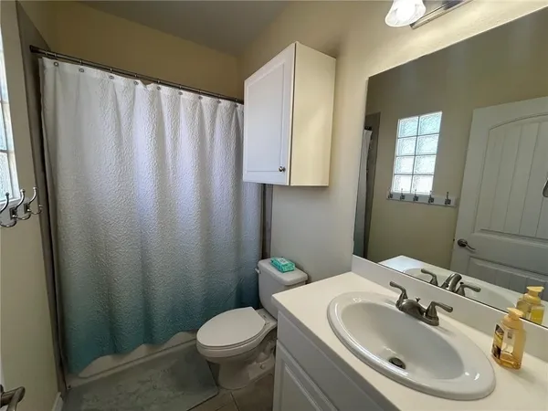 a bathroom with a sink toilet and mirror