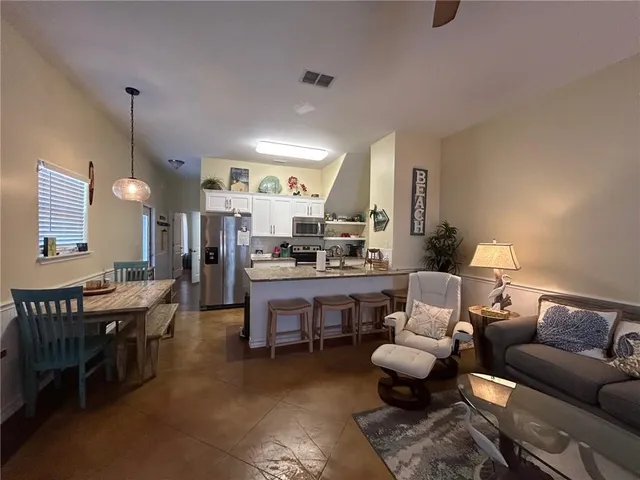 a living room with lots of furniture and kitchen view