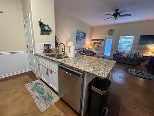 a kitchen with granite countertop kitchen island wooden cabinets and stainless steel appliances