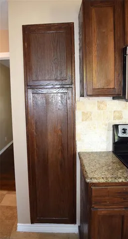a view of kitchen island with granite countertop wooden cabinets