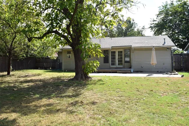a view of a backyard with wooden fence