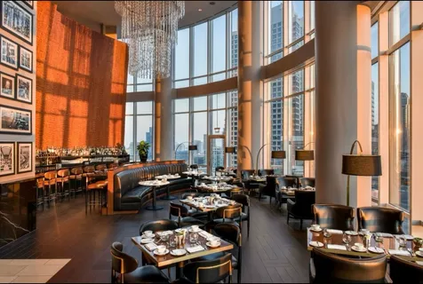 a living room with furniture and floor to ceiling windows