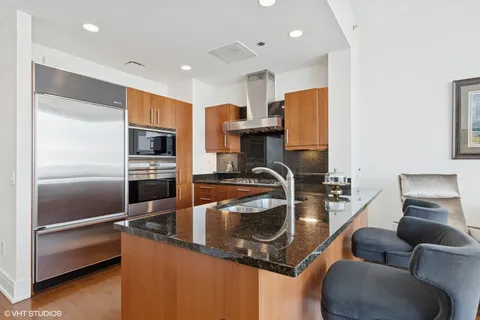 a kitchen with kitchen island stainless steel appliances a sink refrigerator stove and microwave