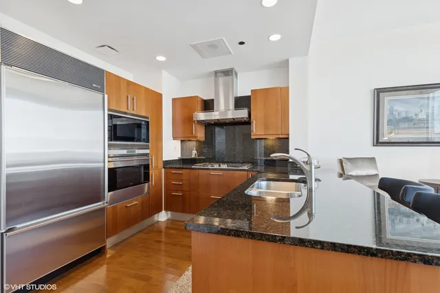 a kitchen with stainless steel appliances granite countertop a sink refrigerator and microwave