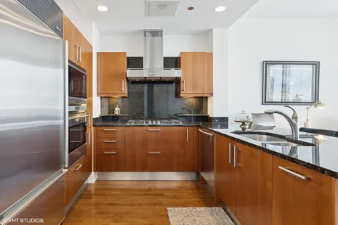 a kitchen with stainless steel appliances granite countertop a refrigerator and a sink