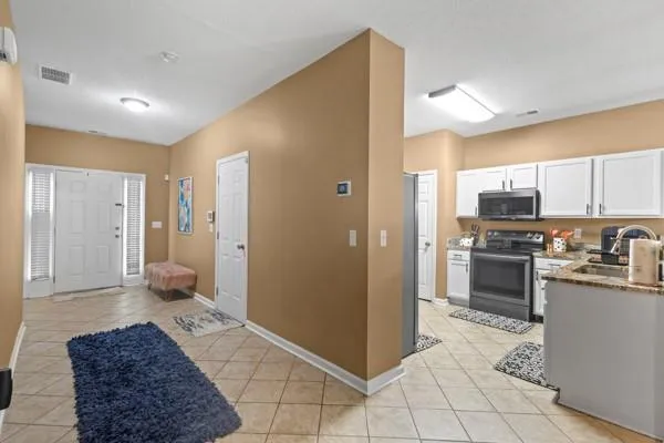 a large kitchen with white cabinets and stainless steel appliances